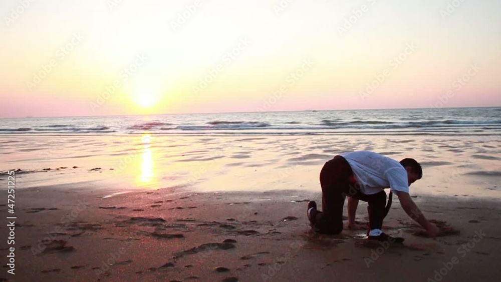 Homme pratiquant de la gymnastique sur la plage