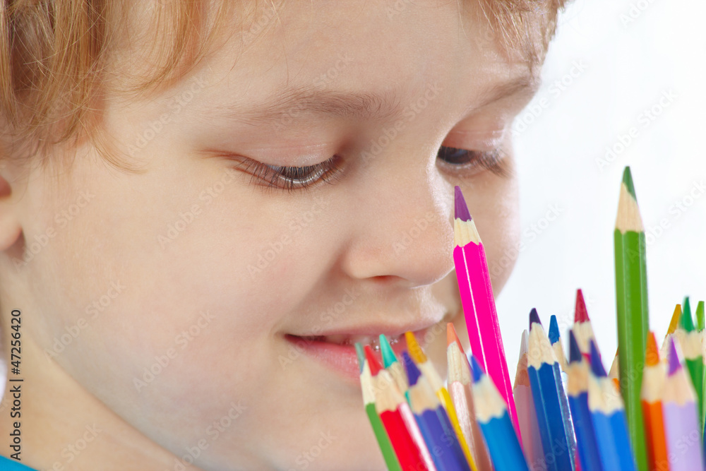 Young cute blond boy looks on color pencils Young cute blond boy looks on color pencils