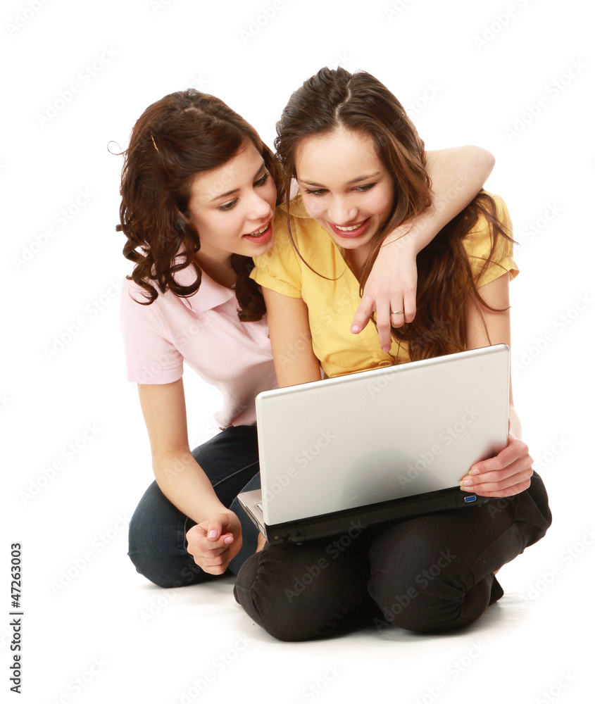 Young girls sitting on the floor with a laptop Young girls sitting on the floor with a laptop