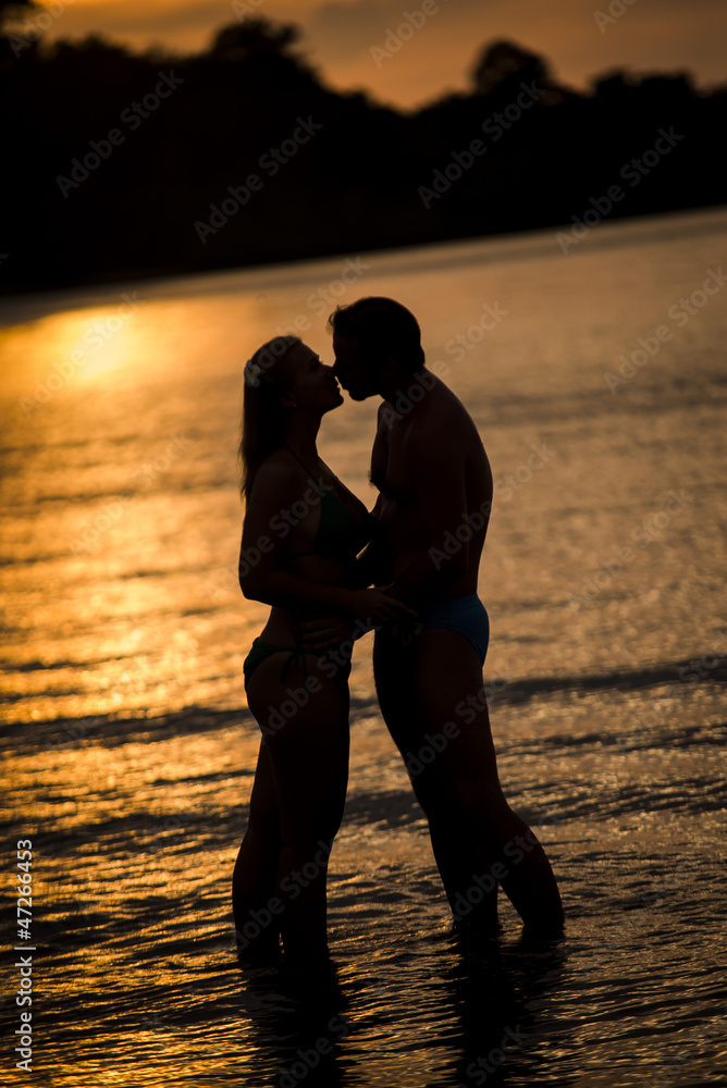 man and woman kiss on the beach having fun