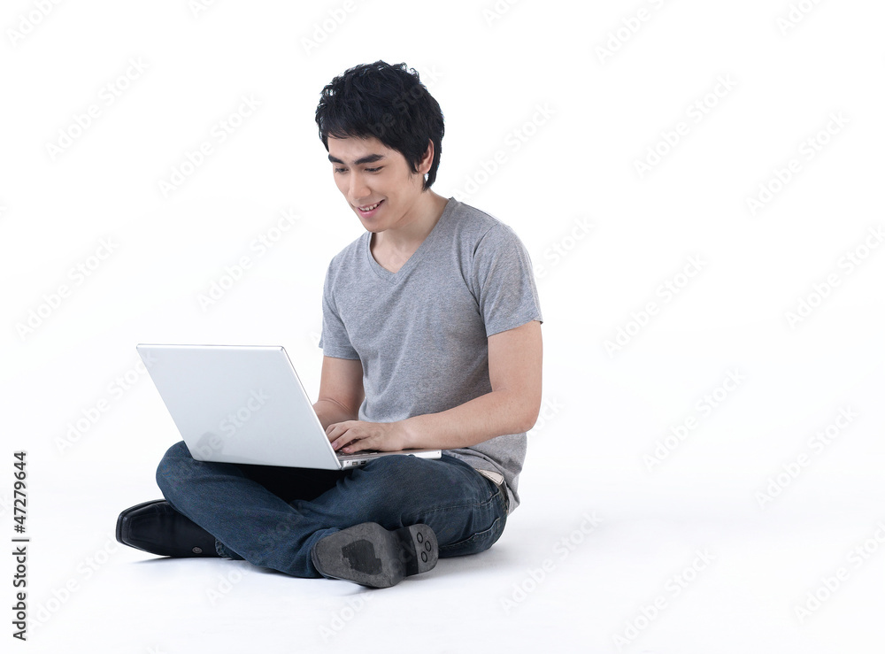 Young man sitting on the floor and work with laptop computer Young man sitting on the floor and work with laptop computer