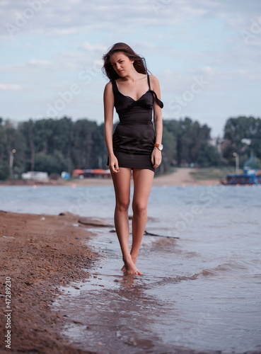 Beautiful young woman near the water