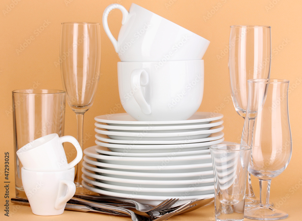 Clean white dishes on beige background Clean white dishes on beige background