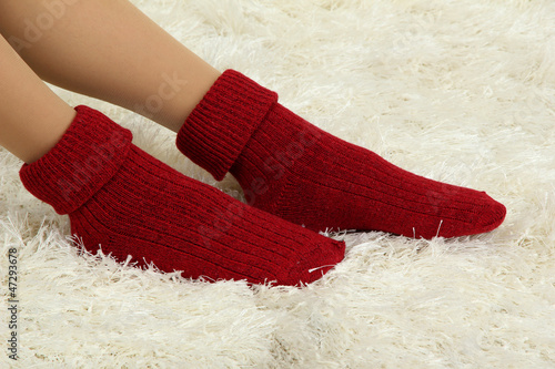 Female legs in colorful socks on  white carpet background