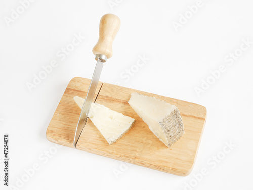 sheep cheese with knife on wood