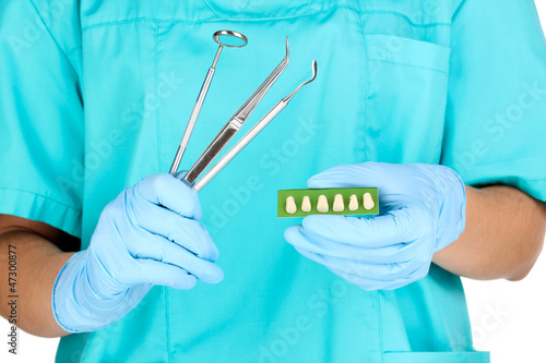 dentists hands in blue medical gloves with dental tools and
