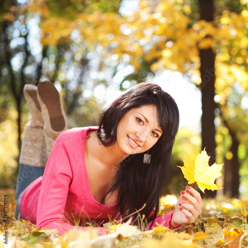 Young pretty woman resting in the autumn park