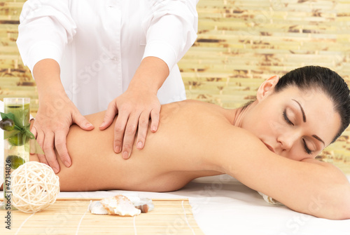 Woman on therapy massage of back in spa salon