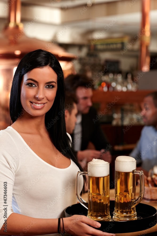Beautiful waitress serving beer