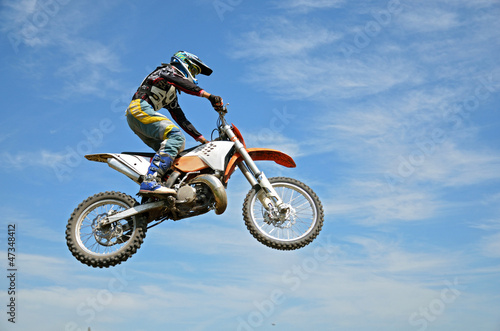 High flight by motorcycle racer motocross against the blue sky