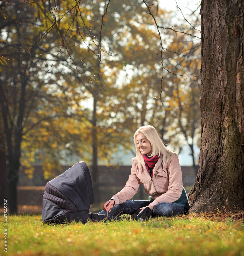 A young mother with her child in a park in autumn A young mother with her child in a park in autumn