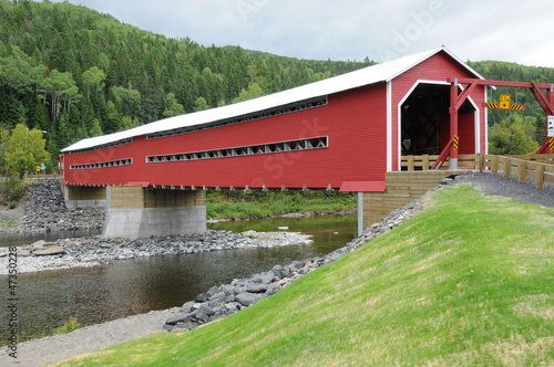 Quebec, a red covered bridge on Matapedia river in Gaspesie photo