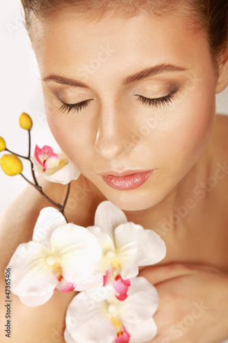 A young woman with orchid  isolated on white