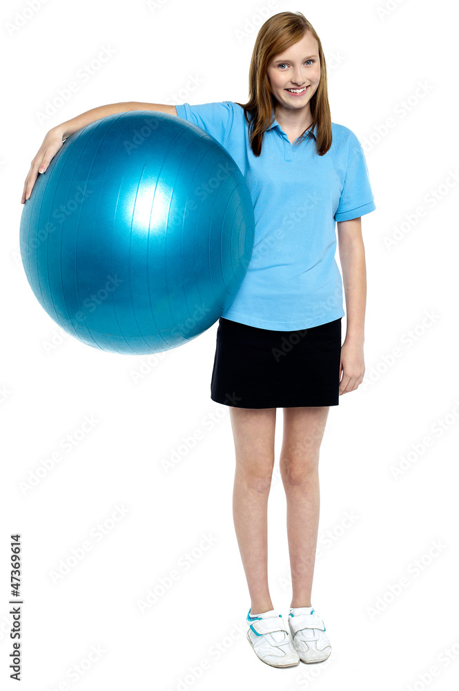 Slim and fit teen girl holding a swiss ball Slim and fit teen girl holding a swiss ball