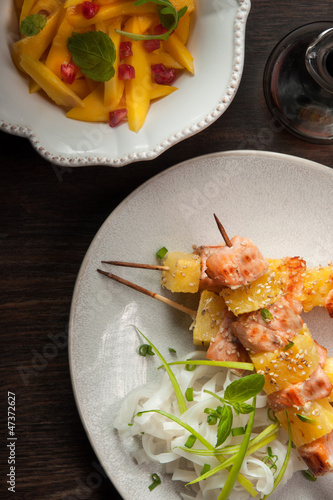salmon skewers with pineapple, rice noodles and mango salad