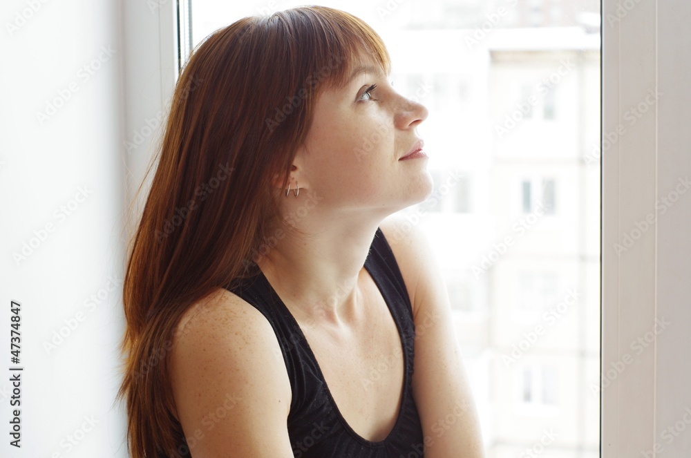 Portrait of woman at a window overlooking the next house Portrait of woman at a window overlooking the next house