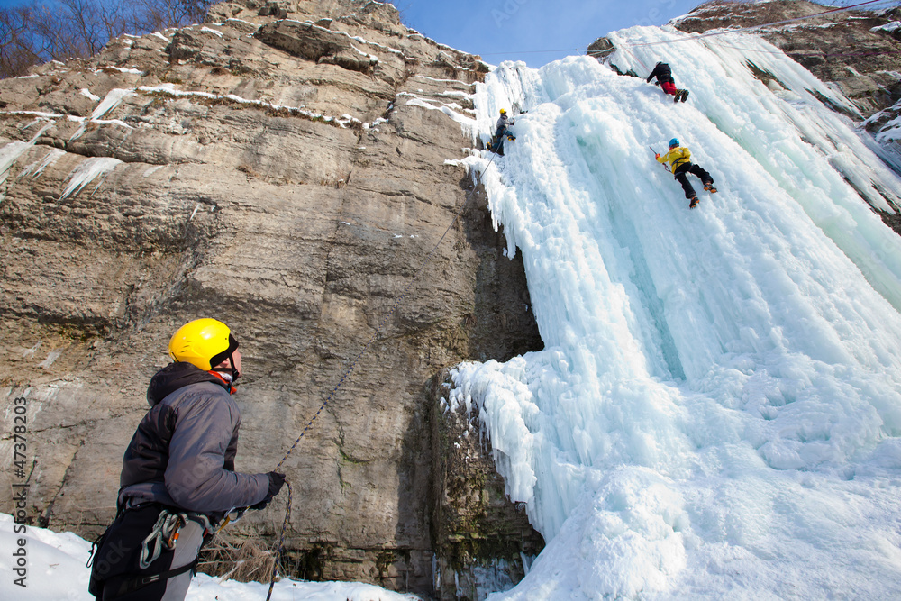 Man climbing frozen waterfall Man climbing frozen waterfall