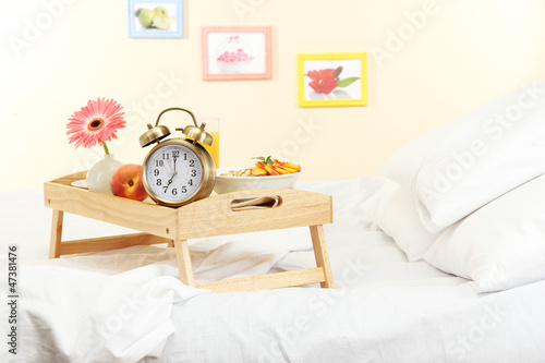wooden tray with light breakfast on bed