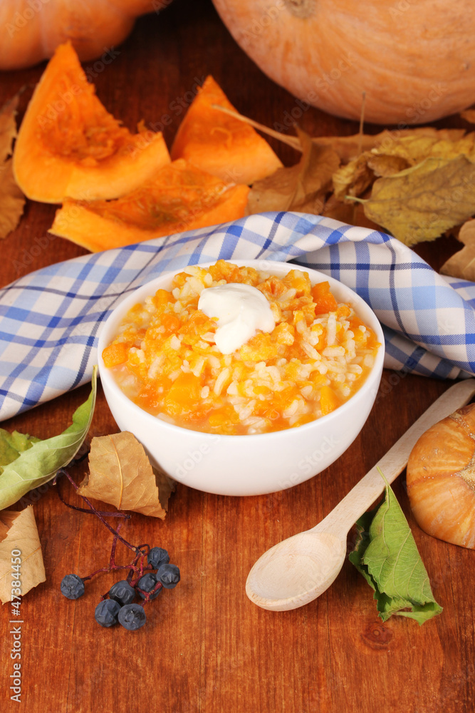 Useful pumpkin porridge in white plate on wooden table close-up