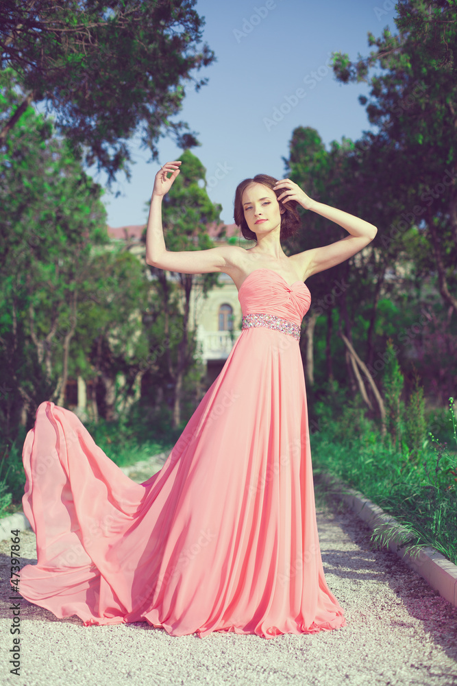 young woman in bright dress posing outdoor, spring