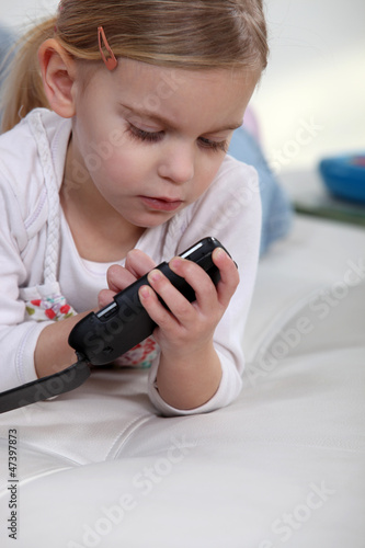 Little girl playing with mobile telephone