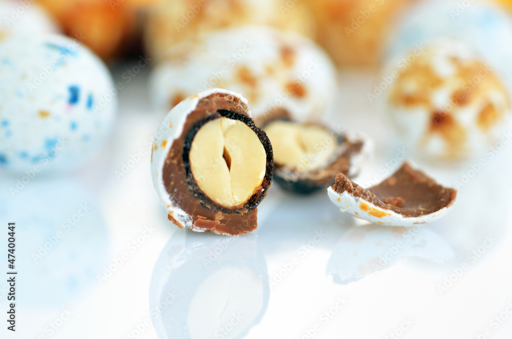 Candy with peanuts covered with multicolored glaze on a white ba Candy with peanuts covered with multicolored glaze on a white ba