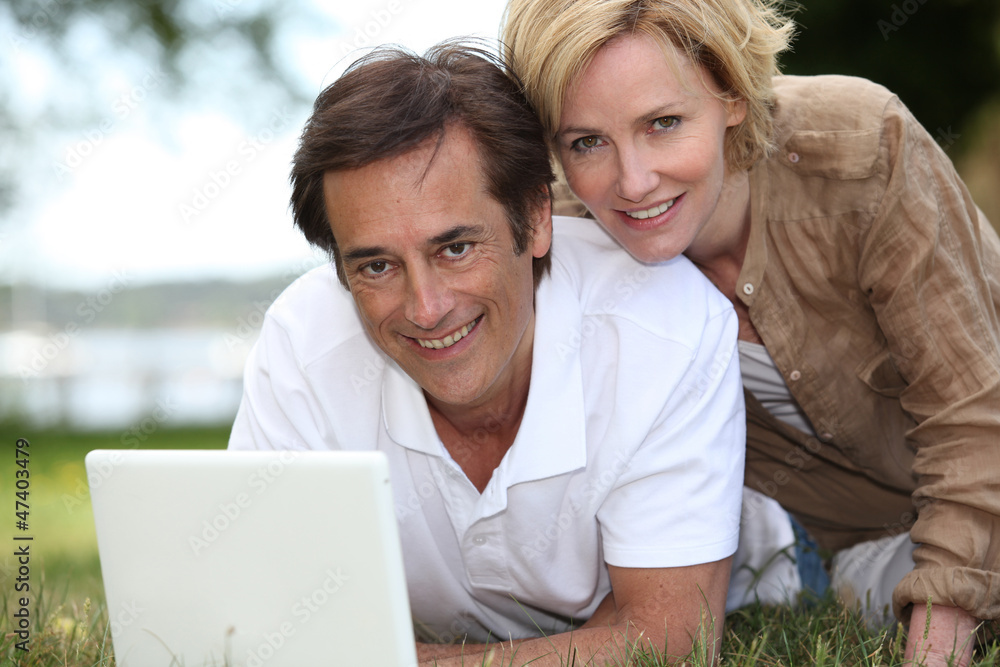 Couple on grass with computer Couple on grass with computer