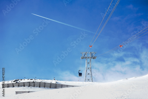 Funicular in alpine mountains on sunny winter day