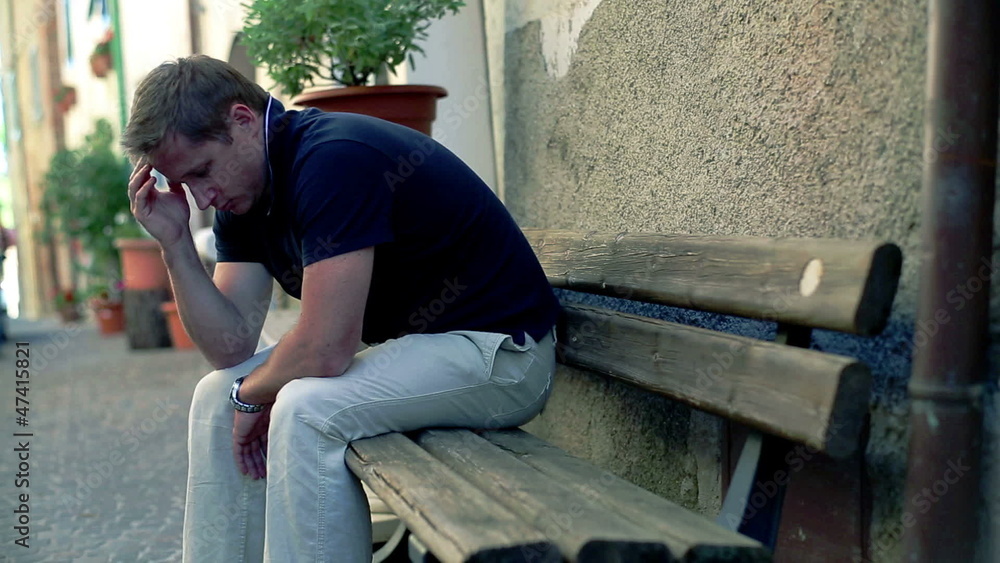 Sad man sitting on bench in the city Sad man sitting on bench in the city