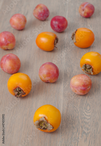 Persimmon fruit and pink plums