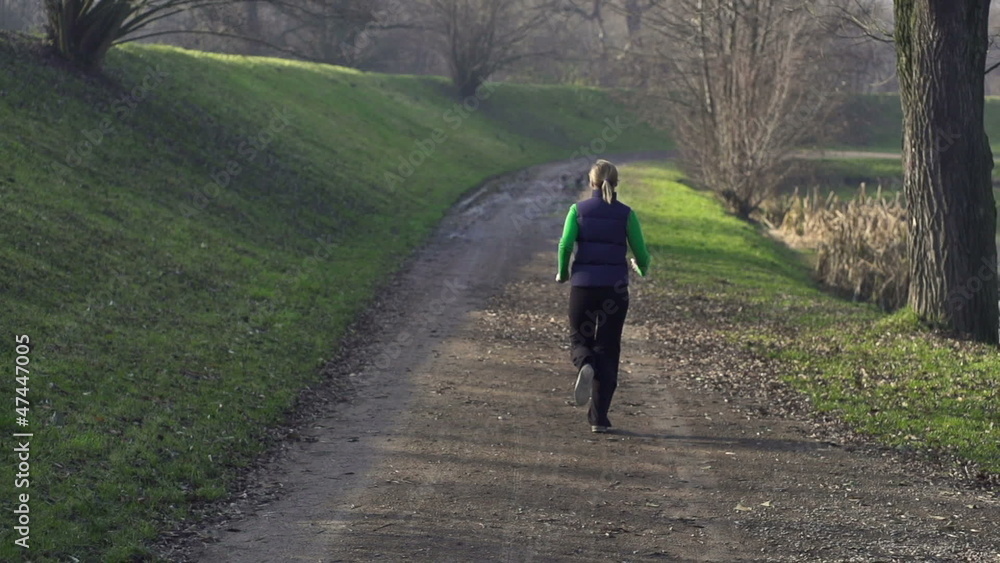 Woman jogging in park, crane shot Woman jogging in park, crane shot