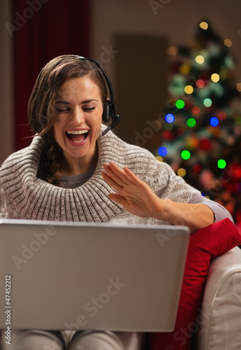 Happy young woman having video chat with family