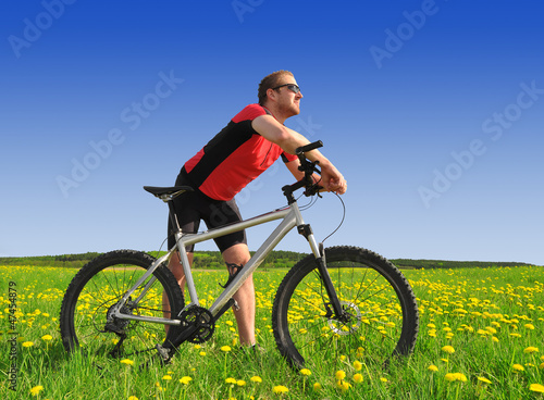 biker with the mountain bike in the dandelion field