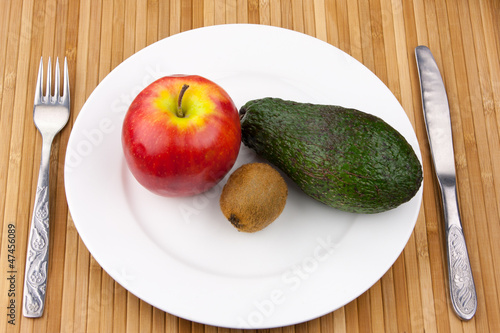 kiwi, avocado and apple on a plate with cutlery photo