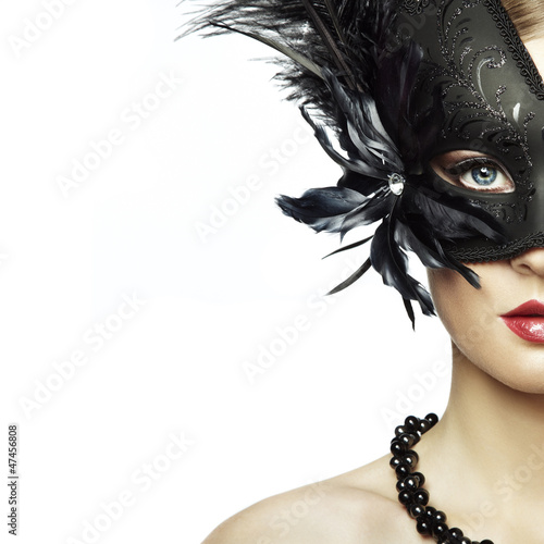 Beautiful young woman in black mysterious venetian mask photo