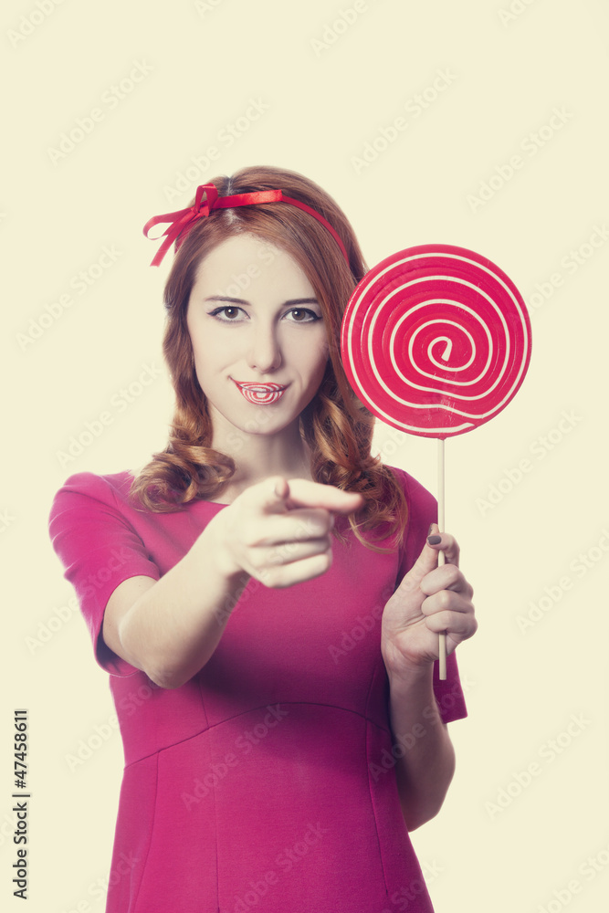 Beautiful redhead girl with lollipop. Photo in retro style.