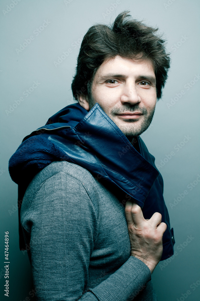 Fototapeta premium Portrait of a happy fashionable handsome man in gray sweater (pu
