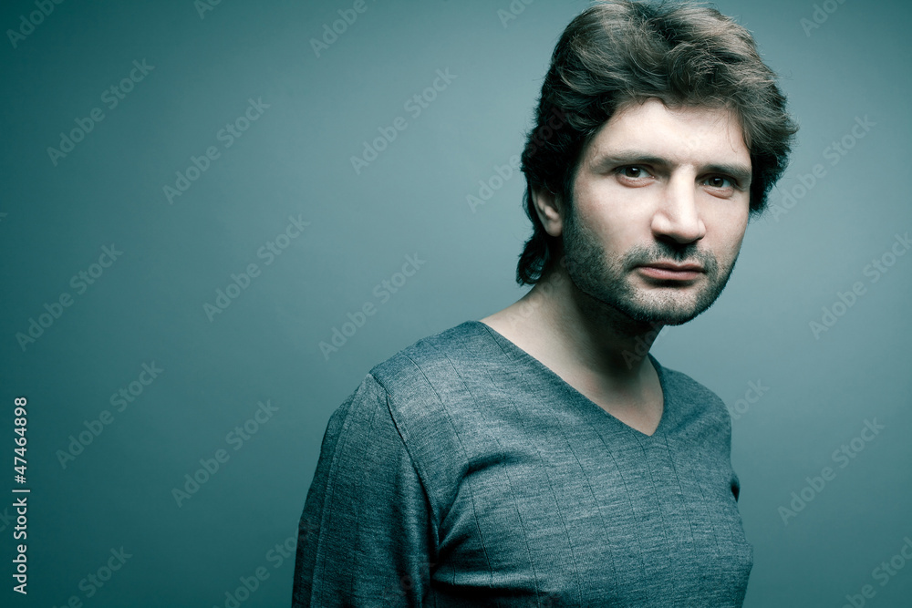 Portrait of a fashionable handsome man in gray sweater (pullover Portrait of a fashionable handsome man in gray sweater (pullover