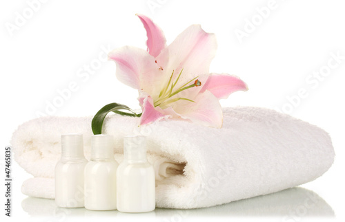 beautiful lily with towel and bottles isolated on white