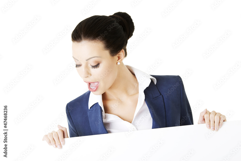 Smiling businesswoman showing blank signboard Smiling businesswoman showing blank signboard