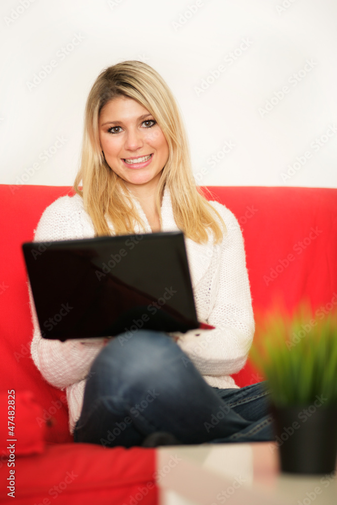 Blonde Frau mit Laptop auf dem Sofa Blonde Frau mit Laptop auf dem Sofa