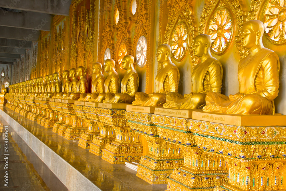 Fototapeta premium row of golden monk buddhist statues in thai temple, Chaimongkhol