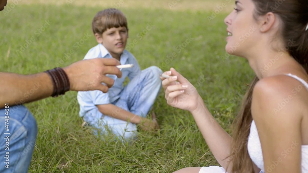 Little boy looking at parents smoking cigarette and talking Little boy looking at parents smoking cigarette and talking