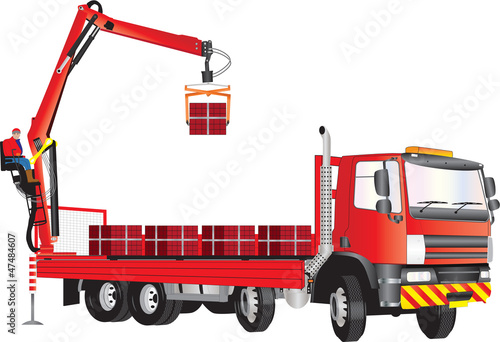 A Red Truck with operator on crane unloading bricks