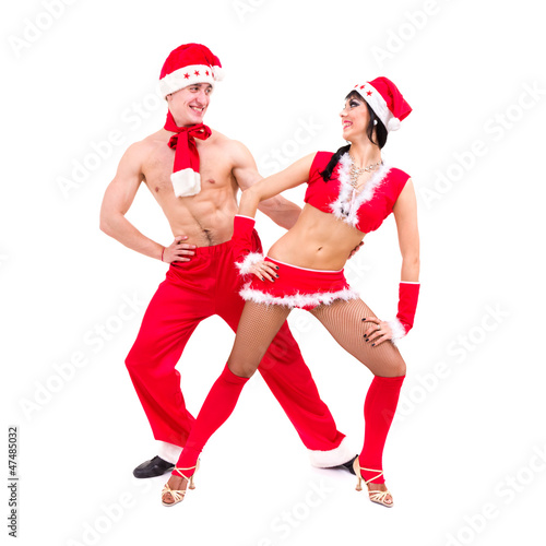 Happy young couple wearing santa claus clothes dancing