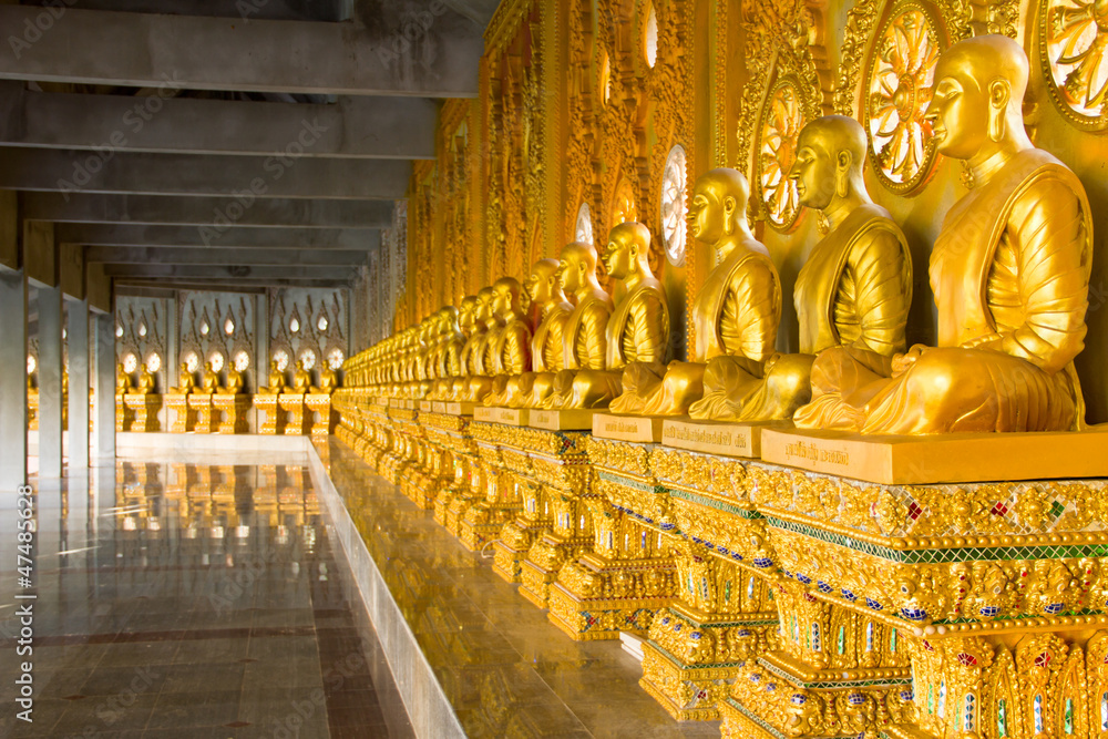 Fototapeta premium row of golden monk buddhist statues in thai temple, Chaimongkhol