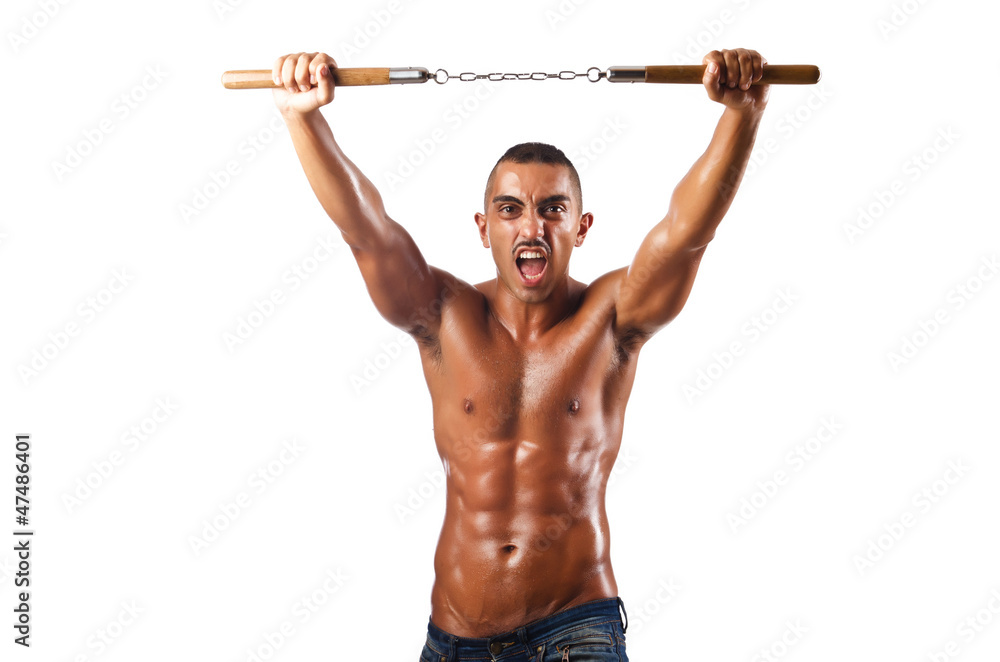 Man in martial arts concept with nunchucks Man in martial arts concept with nunchucks