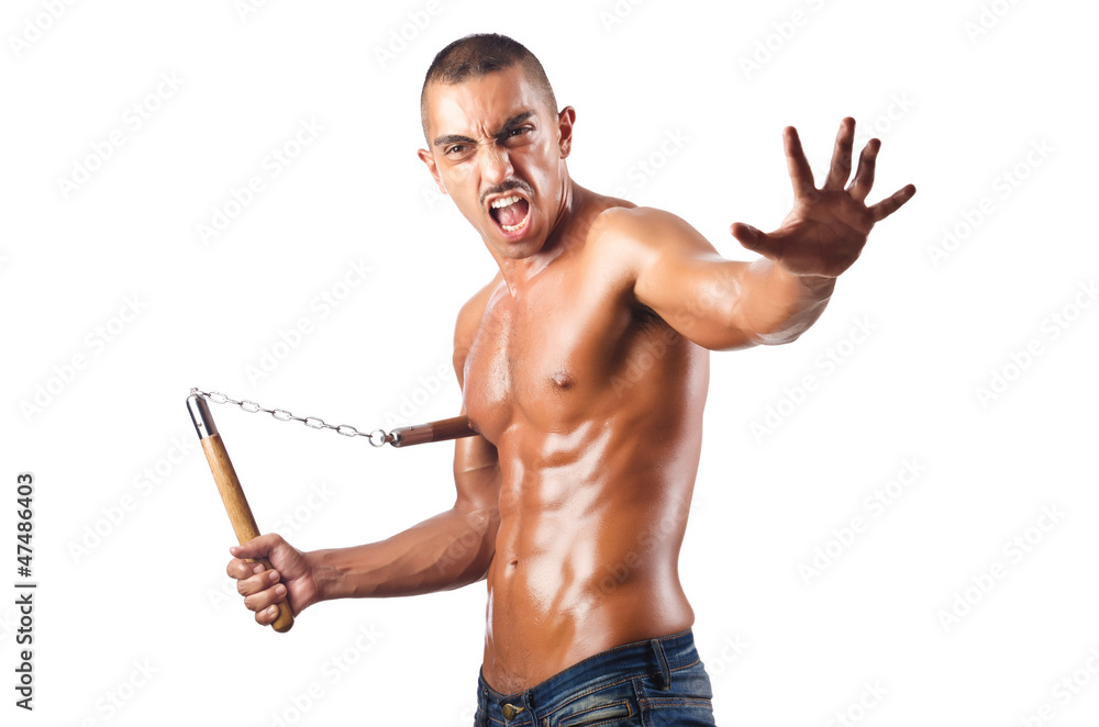 Man in martial arts concept with nunchucks Man in martial arts concept with nunchucks