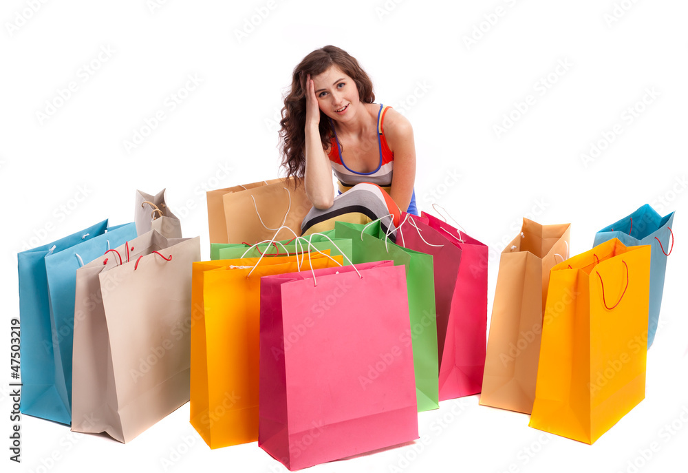 A girl sitting next to a shopping bag