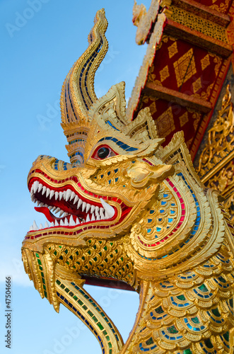 golden serpent statue head in buddhist thai temple in thailand